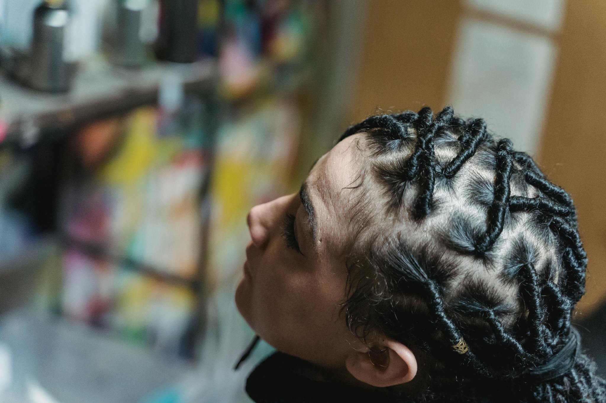 Detailed view of artistic twisted black hairstyle on a woman showcasing hair texture.